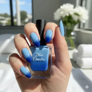 Creative nail art design showing an ombre or gradient effect transitioning from light to deep blue nail polish colors.