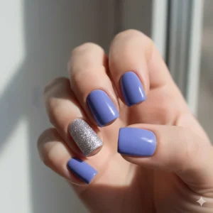 Modern nail art design using periwinkle nail polish as the main color with a glittery silver accent nail.