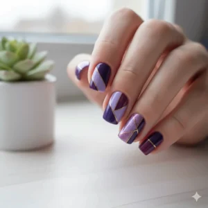 Detailed geometric nail art created using various shades of purple nail polish.