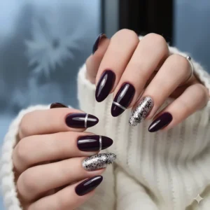 Elegant nail art design featuring a mix of dark purple nail polish and silver details.