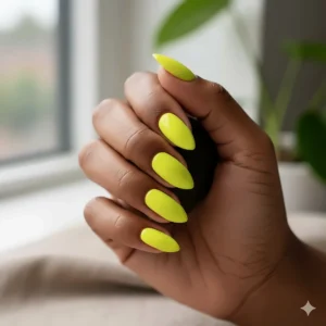 Hand model with a deep skin tone showcasing how bright neon yellow nail polish pops against the skin.