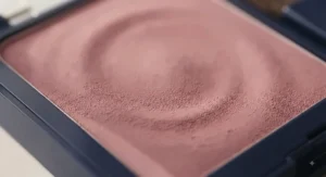 Macro shot showing the fine, oil-absorbing texture of a pressed powder blush designed for oily skin.