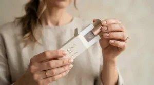 A close-up of hands unboxing a compact contour stick for on-the-go touch-ups
