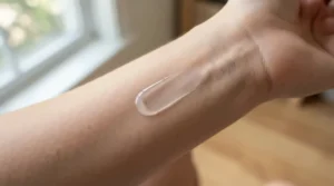 A smooth texture swatch of a mattifying primer for combination skin displayed on the back of a hand.