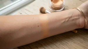 Hand showing the subtle shimmer of a natural-looking bronzer for everyday wear.